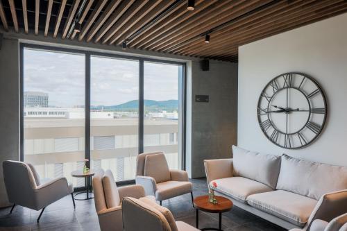 a living room with a large clock and chairs at MOOI Apartments Schlieren in Schlieren