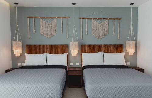 two beds in a hotel room with at Phantom Suites in Playa del Carmen
