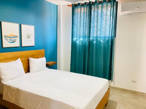 een slaapkamer met een bed en een blauw gordijn bij Flat Aquamare Monte Vista in Sosúa