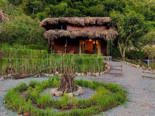 a small hut with a tree stump in front of it at Mường sang Retreat Mộc Châu in Mộc Châu