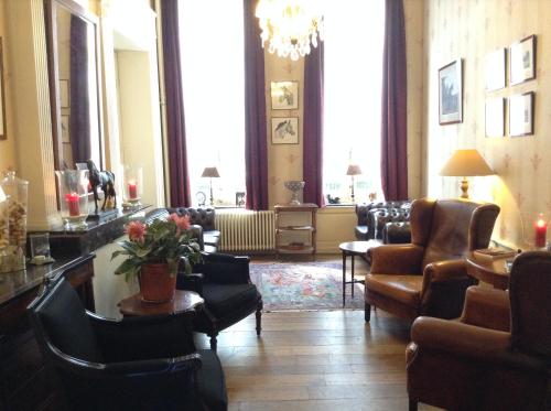 a living room with couches and a table and chairs at Hotel Patritius in Bruges