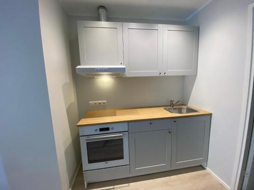 a small kitchen with white cabinets and a sink at Captain's House - Kaptenimaja - Apartments in Kärdla