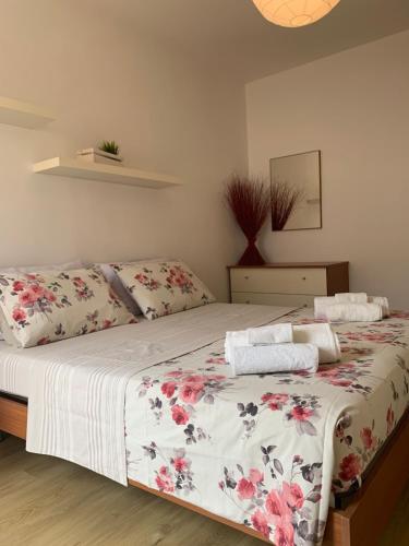 sypialnia z łóżkiem z narzutą w kwiaty w obiekcie CLO APARTMENT w mieście Toscolano Maderno