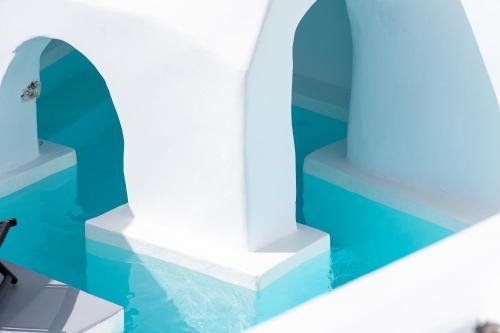 a room with blue and white walls and water at Alme Luxury Cave Villas in Vóthon