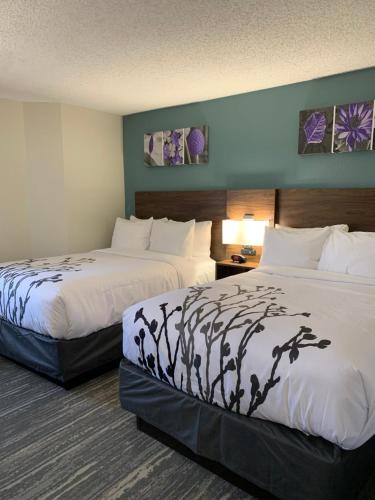 a hotel room with two beds in a room at Sleep Inn & Suites California MD in California