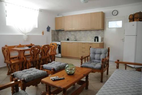 sala de estar con mesa y sillas y cocina en Guest House, en Agioi Theodoroi