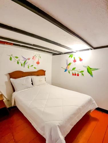 a bedroom with a bed with birds on the wall at Ccapaq Wasi in Cusco