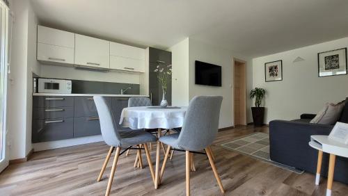 eine Küche und einen Tisch mit Stühlen im Wohnzimmer in der Unterkunft Apartma Julija in Luče