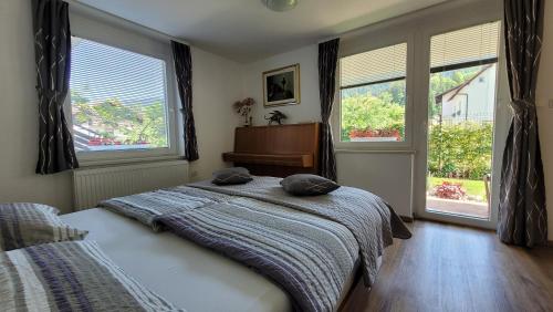 een slaapkamer met een bed, een piano en ramen bij Apartma Julija in Luče