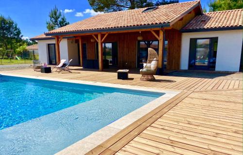 a house with a swimming pool in front of a house at Magnifique villa avec piscine in Escource
