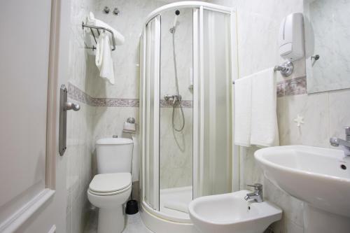 La salle de bains est pourvue d'une douche, de toilettes et d'un lavabo. dans l'établissement Hostal Costa Coruña, à La Corogne