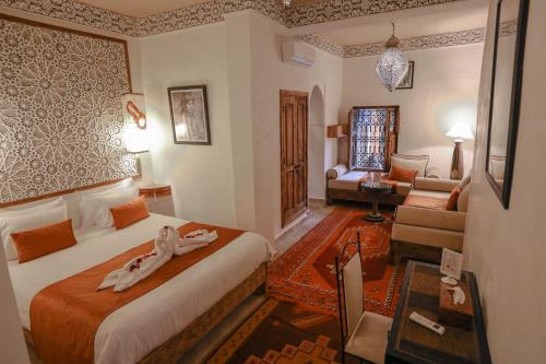 a hotel room with two beds and a living room at Riad Anya & SPA in Marrakech