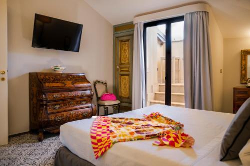 a bedroom with a bed and a television on the wall at Hotel Villa Taormina in Taormina