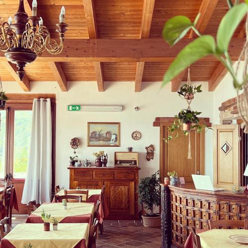 un ristorante con tavoli, lampadario a braccio e soffitti in legno di Trasicca B&B a Talavà