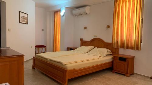 a bedroom with a bed and a table and a window at Guest House Katya in Nesebar