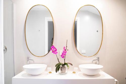 a bathroom with two sinks and two mirrors at Hotel Villa Taormina in Taormina