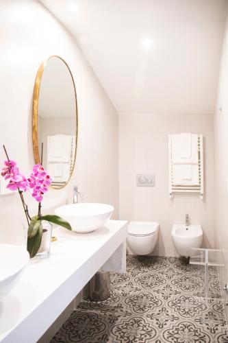 a white bathroom with two sinks and a mirror at Hotel Villa Taormina in Taormina