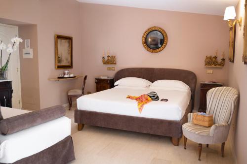 a bedroom with a large bed and a chair at Hotel Villa Taormina in Taormina