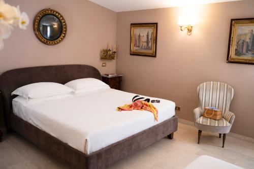 a bedroom with a bed and a chair at Hotel Villa Taormina in Taormina