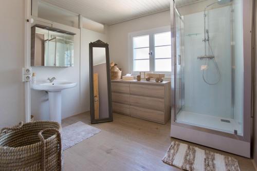 uma casa de banho com um chuveiro e um lavatório. em Maison du bois em Saint-Antoine