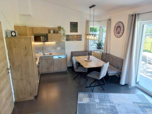eine Küche und ein Wohnzimmer mit einem Tisch und einem Esszimmer in der Unterkunft Appartement Beate in Brixen im Thale