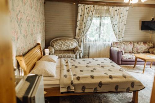 a bedroom with a bed and a couch and a window at Hotel Velyka Vedmedytsya in Yaremche