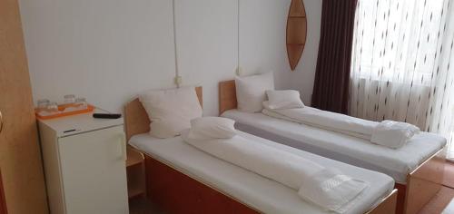 um quarto com 2 camas e almofadas brancas em CASA ICA em Baile Felix