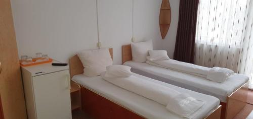 a room with two beds with white pillows at CASA ICA in Baile Felix