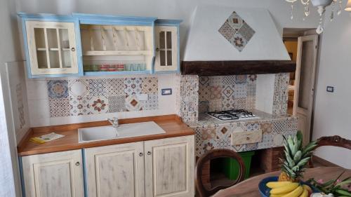 a small kitchen with a sink and a stove at La Terrazza nel cuore di Capoliveri in Capoliveri