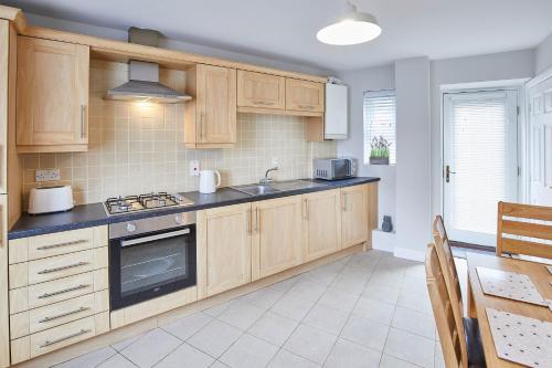 a kitchen with wooden cabinets and a sink at Host & Stay - Aynsley Mews in Consett
