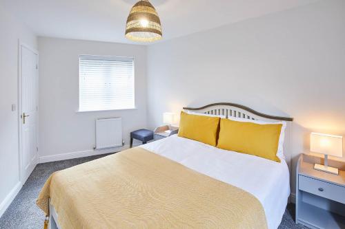 1 dormitorio con 1 cama grande con almohadas amarillas en Host & Stay - Aynsley Mews, en Consett