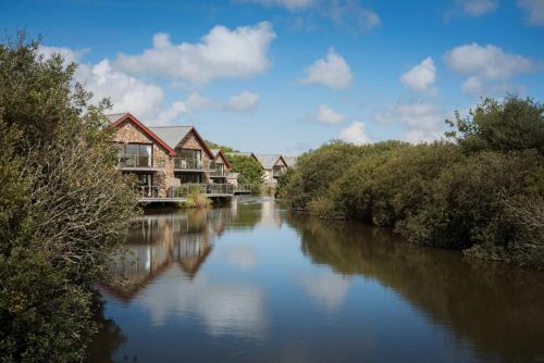 a river with houses on the side of it at Fistral hot tub house for 8 on Retallack Resort in Newquay