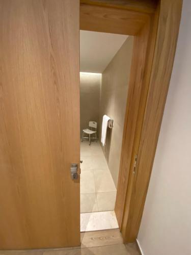 a hallway with a door leading to a room with a table at Hasanah suites in Al Madinah