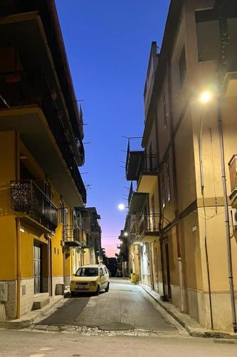 ein Auto, das auf einer Straße zwischen zwei Gebäuden parkt in der Unterkunft Casa Casteldaccia 3 in Casteldaccia