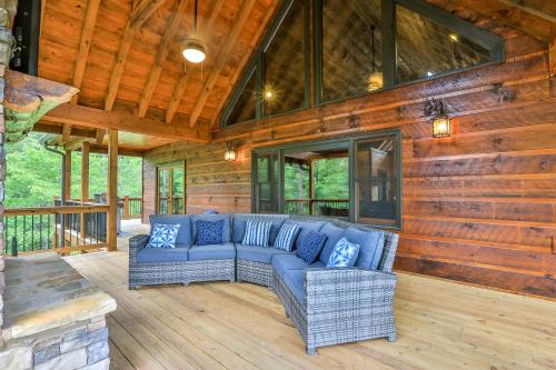 a living room with a blue couch on a deck at Highlands Retreat the Perfect Cabin for your relaxing experience in Mineral Bluff