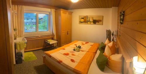 a small bedroom with a bed with flowers on it at Haus am Achengrund in Kössen