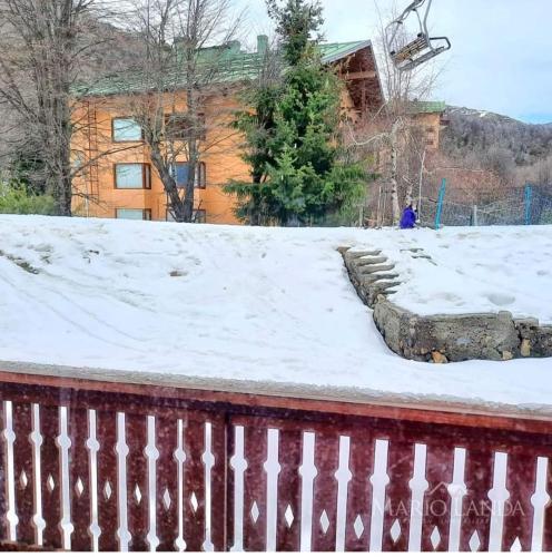 a pile of snow on a fence in front of a house at Departamento pie de pista Nevados de Chillán in Pinto