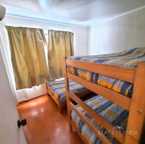 a bedroom with two bunk beds and a window at Departamento pie de pista Nevados de Chillán in Pinto