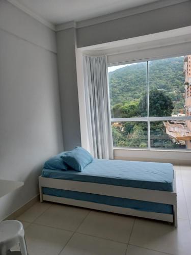 - une chambre avec un lit et une grande fenêtre dans l'établissement Loft Bombinhas Van Gogh, à Bombinhas