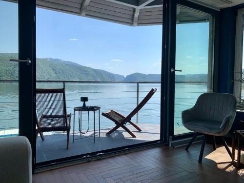 a screened in porch with a view of the water at CASA 9 - villa & spa in Eşelniţa