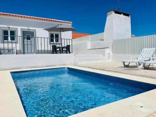 a swimming pool in front of a house at Casa do Carmo in Sousel