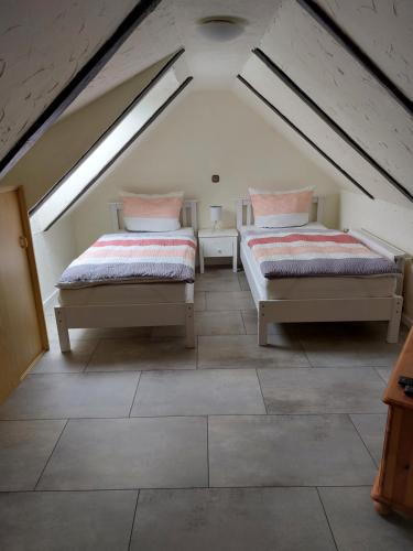 two beds in a attic room with a roof at Ferienwohnung Thamm in Lage
