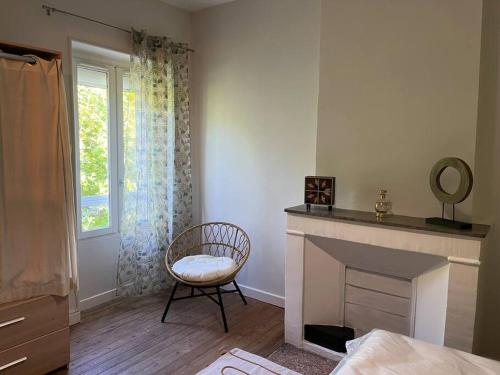 uma sala de estar com uma cadeira e uma lareira em Très bel appartement tout proche du centre ville em Montélimar