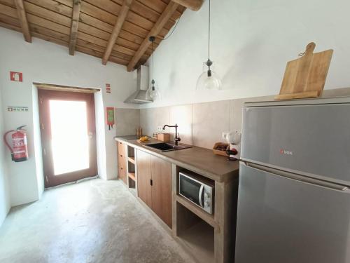 a kitchen with a stainless steel refrigerator and wooden cabinets at Casa Torta in Outeiro