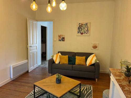 uma sala de estar com um sofá e uma mesa em Très bel appartement tout proche du centre ville em Montélimar