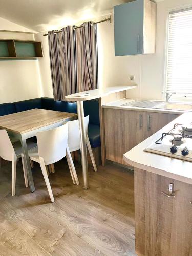 a kitchen with a table and some chairs and a table at Camping Village Nice Garden in Ardea