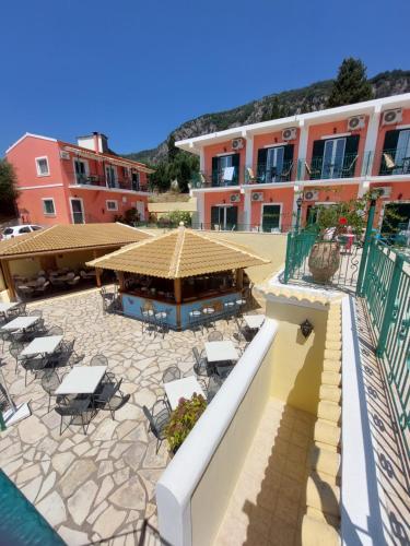 un resort con piscina, sedie e un edificio di Maria Studios a Paleokastritsa