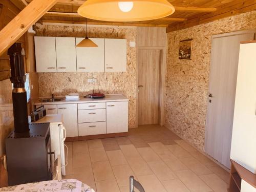 een keuken met witte kasten en een fornuis bij Bungalow Perun in Blejska Dobrava