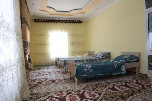 a bedroom with two beds and a window at FOREST Guest House in Mirzakishlak