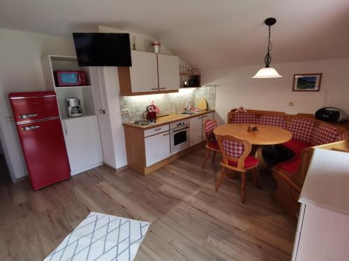 a kitchen and dining room with a table and a red refrigerator at Ferienwohnungen Böhm in Sankt Jakob in Defereggen
